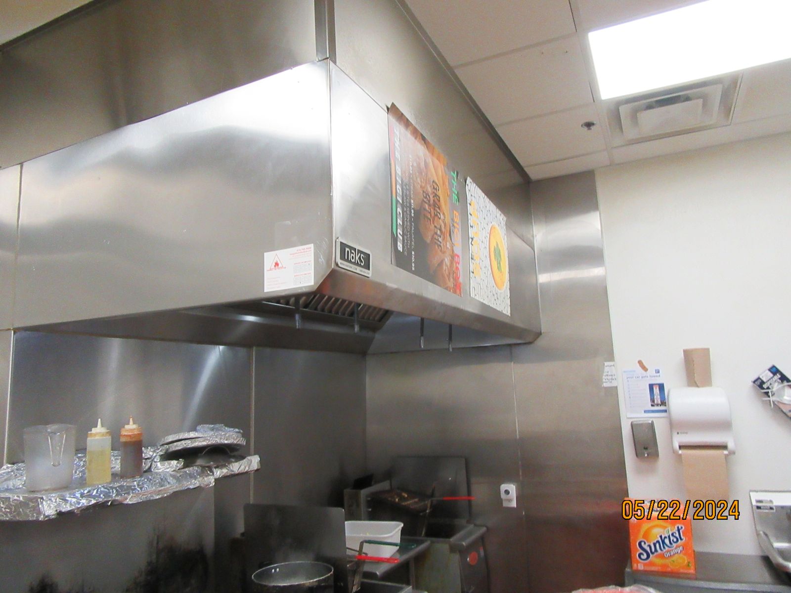 Stainless steel kitchen exhaust hood over the cooking line.