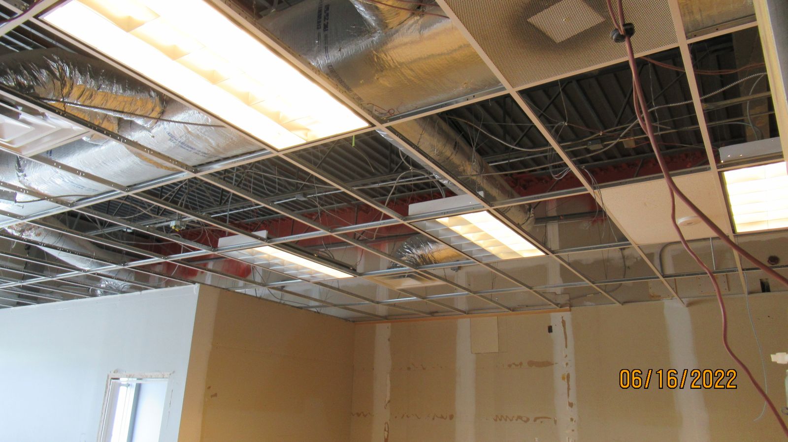 Ceiling lighting and ductwork installed in the dining area.